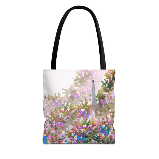 Tote bag with a woman standing in a field of flowers in pink, blue, magenta and green. and black handle on a white background