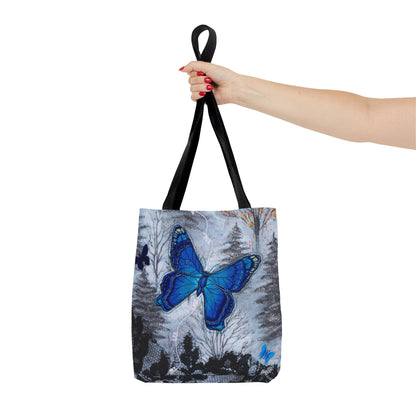 Tote bag with a blue butterfly design held by a hand on a white background