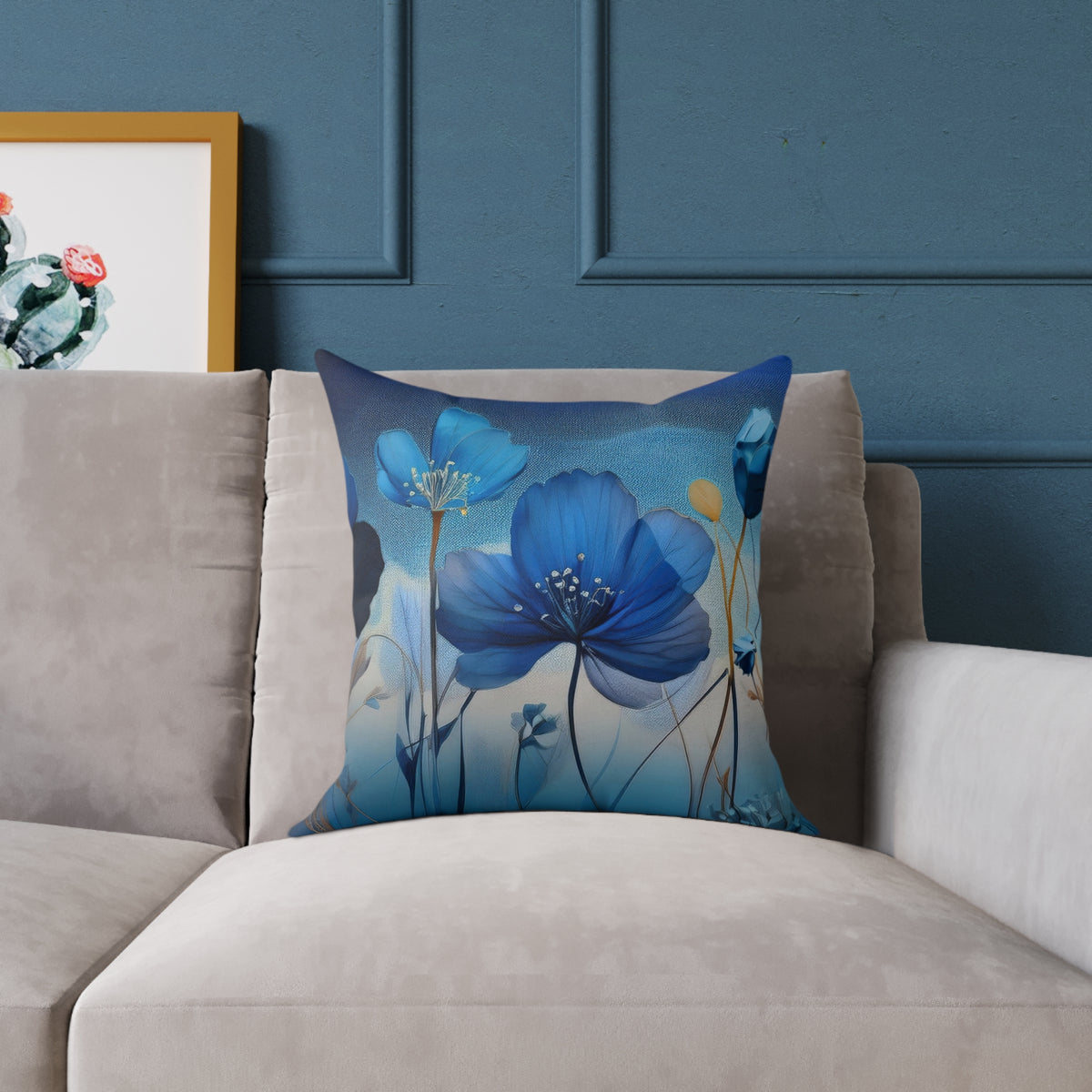 Decorative pillow with blue floral design on a gray sofa against a blue wall.